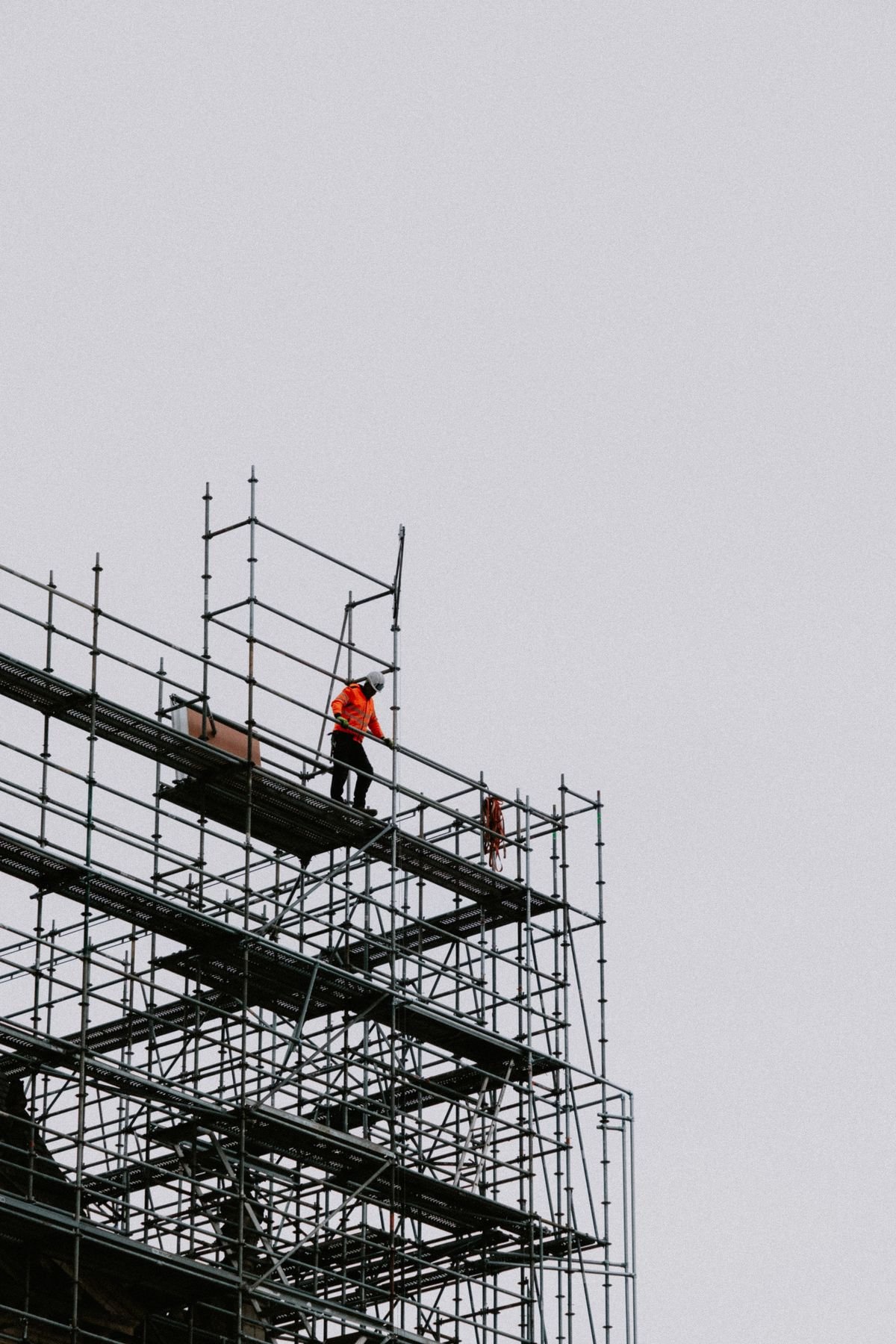 Trabajador de la construcción con equipo de seguridad sobre un andamio